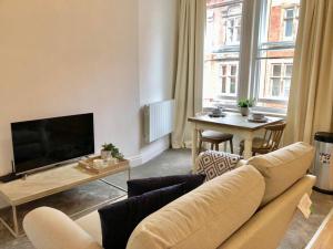 a living room with a couch and a table at NG1 Lofts in Nottingham