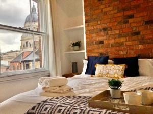 uma cama num quarto com uma parede de tijolos em NG1 Lofts em Nottingham