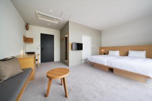 a bedroom with a bed and a table and a couch at MUSTARD HOTEL SHIMOKITAZAWA in Tokyo +94 photos
