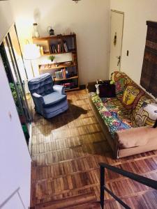 ein Wohnzimmer mit einem Sofa und einem Stuhl in der Unterkunft Penthouse Duplex en Pocitos in Montevideo