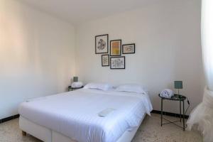 Dormitorio blanco con cama blanca y cuadros en la pared en Superb apt in Cannes - Sea view - 6 people, en Cannes
