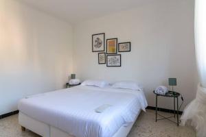 Dormitorio blanco con cama blanca y cuadros en la pared en C078-Superb apt in Cannes - Sea view - 6 people, en Cannes