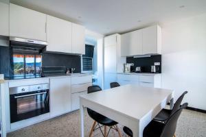 Una cocina con gabinetes blancos y una mesa y sillas. en C078-Superb apt in Cannes - Sea view - 6 people, en Cannes 6 fotos más