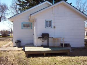 ein kleines weißes Haus mit einem Tisch und einer Bank in der Unterkunft Holiday Cottage in Canora