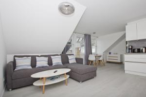 a living room with a couch and a table at Ferienwohnung mit Meerblick und Gartennutzung - Haus Inselwind FeWo MEERstrand in Groß Zicker