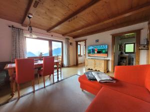 a living room with a red couch and a table at Haus Bergleiten in Alpbach