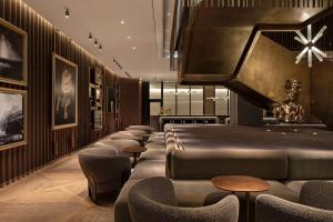 a waiting room with a row of chairs and tables at The Londoner in London +47 photos
