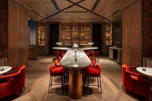 a dining room with a table and red chairs at The Londoner in London