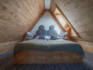 a bedroom with a large bed in a attic at Apartamenty Mrowca in Ząb