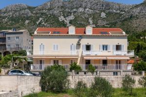 a house with a mountain in the background at Apartments Silvija in Mokošica