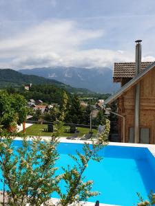 a swimming pool with a view of the mountains at Planika Holiday Home in Bled