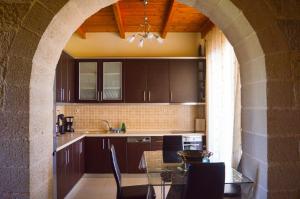 cocina con arco y mesa con sillas en Villa Alexandra, en Stavros