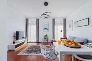 a living room with a table with a bowl of fruit on it at Apartment Łobzowska Cracow by Noclegi Renters in Kraków