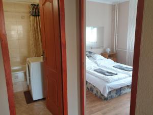 a small bedroom with a bed and a window at Casino Zugló in Budapest