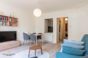 uma sala de estar com um sofá azul e uma mesa em Hélène, appartement vlakbij het strand em Oostende