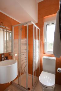 a bathroom with a shower and a toilet and a window at Villa Kiara in Tersanas