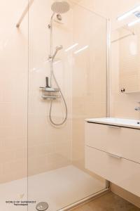 uma casa de banho com um chuveiro e um lavatório. em Hélène, appartement vlakbij het strand em Oostende