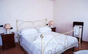 a bedroom with a white bed and two night stands at 4 bedrooms house with lake view enclosed garden and wifi at Amelia in Amelia