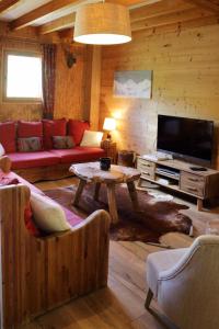 een woonkamer met een bank en een tafel bij Chalet Le Bouton D'or in Les Deux Alpes