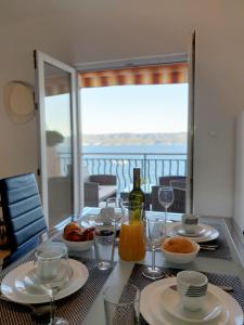a table with plates of food and a bottle of wine at Apartment ZaDoDa in Omiš
