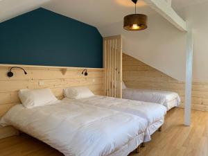 ein Schlafzimmer mit 2 Betten und einer blauen Wand in der Unterkunft Appart-Hotel Les Palombieres in Bagnères-de-Bigorre