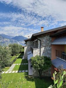 une maison avec une cour herbeuse à côté d'un bâtiment dans l'établissement Appartamenti Elisabeth, à Brenzone