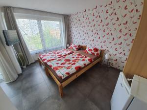 a bedroom with a bed with red sheets and a window at Ferienunterkunft Dolce Vita in Friedrichshafen
