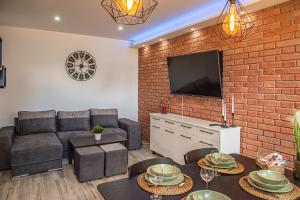a living room with a couch and a brick wall at Apartament u Mirki in Puck