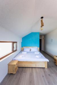 a bedroom with a large bed and a blue wall at Black Sea View Costinesti in Costinesti