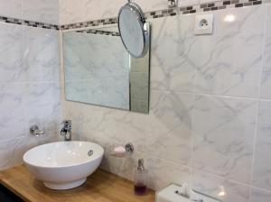 ein Badezimmer mit einem weißen Waschbecken und einem Spiegel in der Unterkunft Chambre tout confort du Tilleul in Bosc-Bénard-Commin