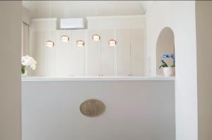a bathroom with white cabinets and a sink with flowers at Hotel London in Viareggio