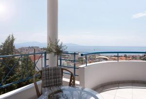 einen Balkon mit einem Tisch und Meerblick in der Unterkunft Vanilla Luxurious Apartment in Kavala