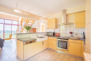 a kitchen with yellow cabinets and a large window at Le Pré devant nous in Picherande