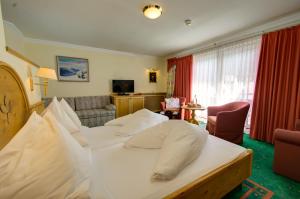 a bedroom with a bed and a living room at Boutique-Hotel Bauer in Saalbach-Hinterglemm