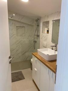 biała łazienka z umywalką i prysznicem w obiekcie Apartments Vala w mieście Grebaštica