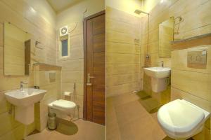 a bathroom with a toilet and a sink and a mirror at FabHotel Prime Empire in Amritsar