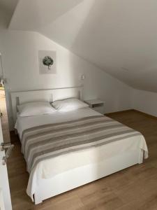 ein Schlafzimmer mit einem weißen Bett in einem Zimmer in der Unterkunft Apartments Vala in Grebaštica