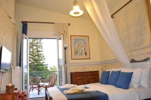 ein Schlafzimmer mit einem Bett mit blauen Kissen und einem Balkon in der Unterkunft Chersonissos Villa Elite in Hersonissos