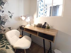 a desk in a bedroom with a chair and a mirror at L'appart de la Vallée-aux-loups by Beds4Wanderlust in Châtenay-Malabry