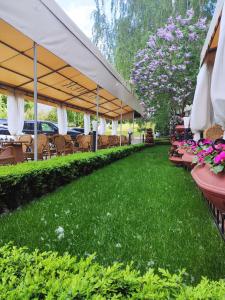 un patio con tavoli, sedie e fiori rosa di Premier Hotel Rus a Kiev
