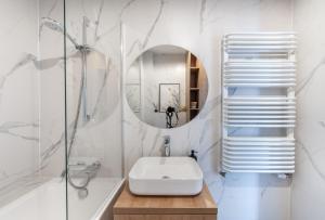 uma casa de banho branca com um lavatório e um espelho em Luxury Port View - BillBerry Apartments em Gdynia