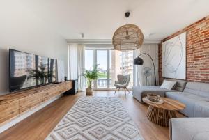 uma sala de estar com um sofá e uma parede de tijolos em Luxury Port View - BillBerry Apartments em Gdynia
