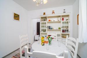 uma sala de jantar branca com uma mesa e cadeiras brancas em Apartment Luka em Dubrovnik