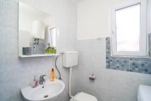 uma casa de banho com um lavatório, um WC e um espelho. em Apartment Luka em Dubrovnik