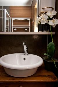 a white sink on a wooden counter with a plant at a Vue Guesthouse in Somerset West