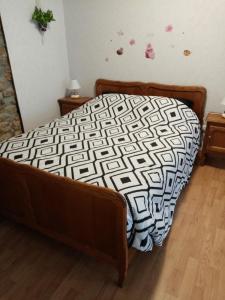 een bed met een wit en zwart dekbed in een slaapkamer bij Chez isa in Saint-Hubert