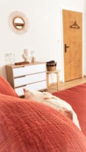 een slaapkamer met een rood bed, een dressoir en een deur bij La Araucania, 2 personnes - WIFI in Rombach-le-Franc
