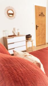 a bedroom with a red bed with a dresser and a door at La Araucania, 2 personnes - WIFI in Rombach-le-Franc +12 photos