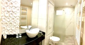a white bathroom with a sink and a toilet at Borostyán Panzió in Kaposvár