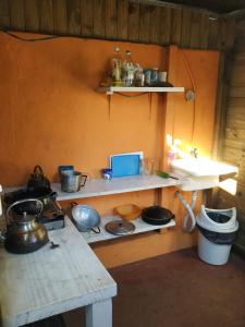 een keuken met een fornuis en planken met potten en pannen bij Iguazu Rey Hostal in Puerto Iguazú